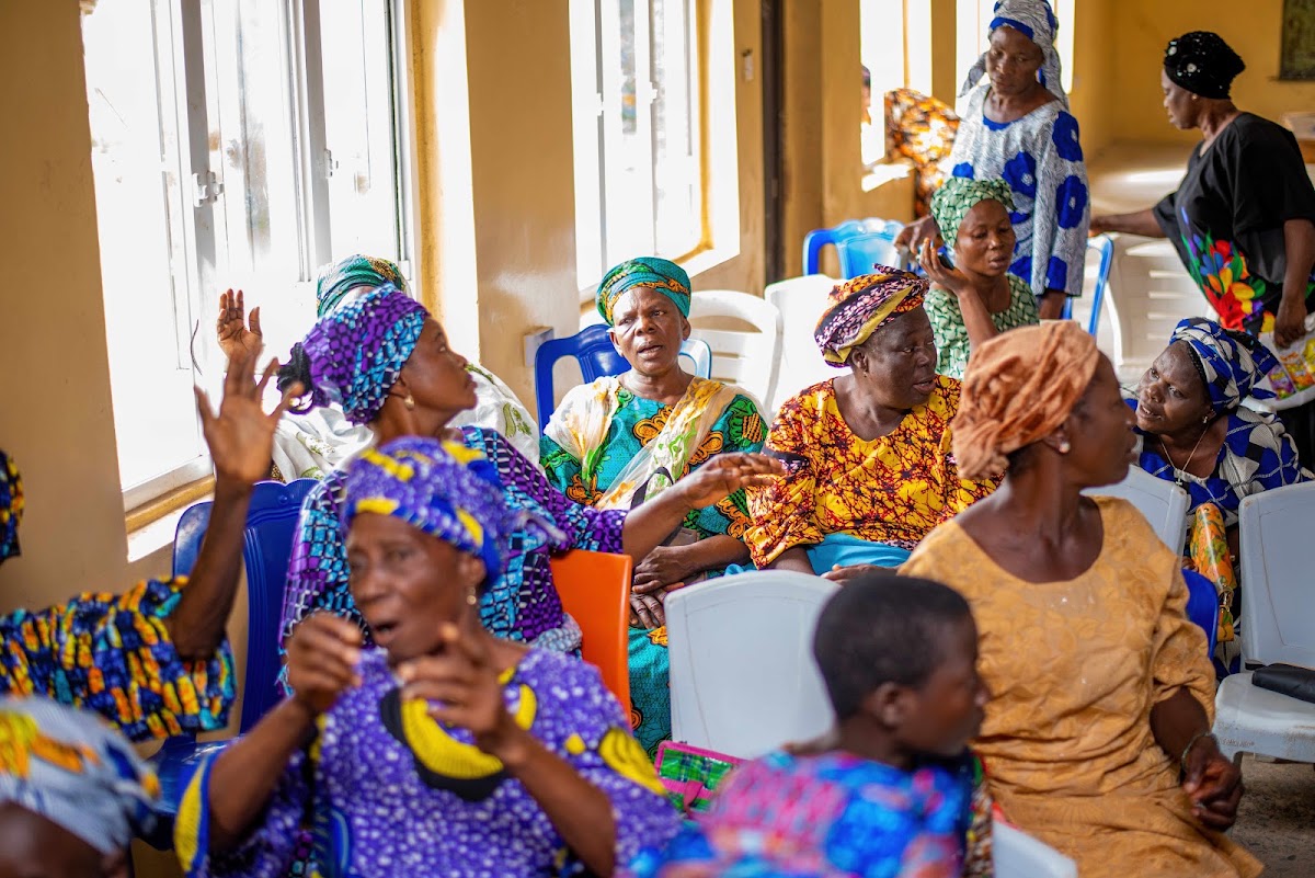 Women seated by tall windows during a foundation gathering.
